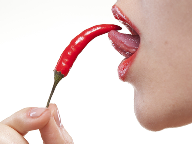 Young woman with chili pepper isolated on white