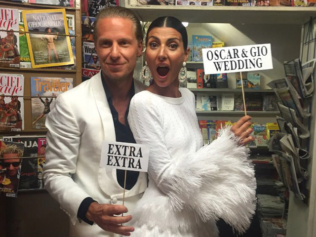 Os noivos Giovanna Battaglia, com look Azzedine Alaïa, e Oscar Engelbert na banca de jornal montada em Capri. Todas as revistas expostas levam fotos divertidas do casal